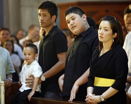 Aquino, her husband Yap holding Baby James and her eldest son Joshua attend a mass for the late former President Aquino on the third day of her mother's wake at Manila Cathedral